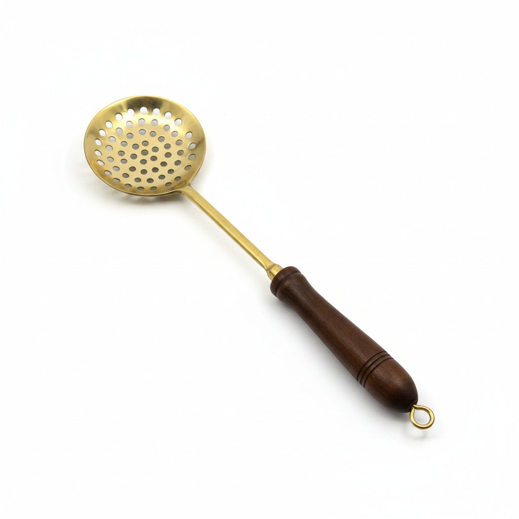 A vintage brass slotted ladle with a dark brown wooden handle.